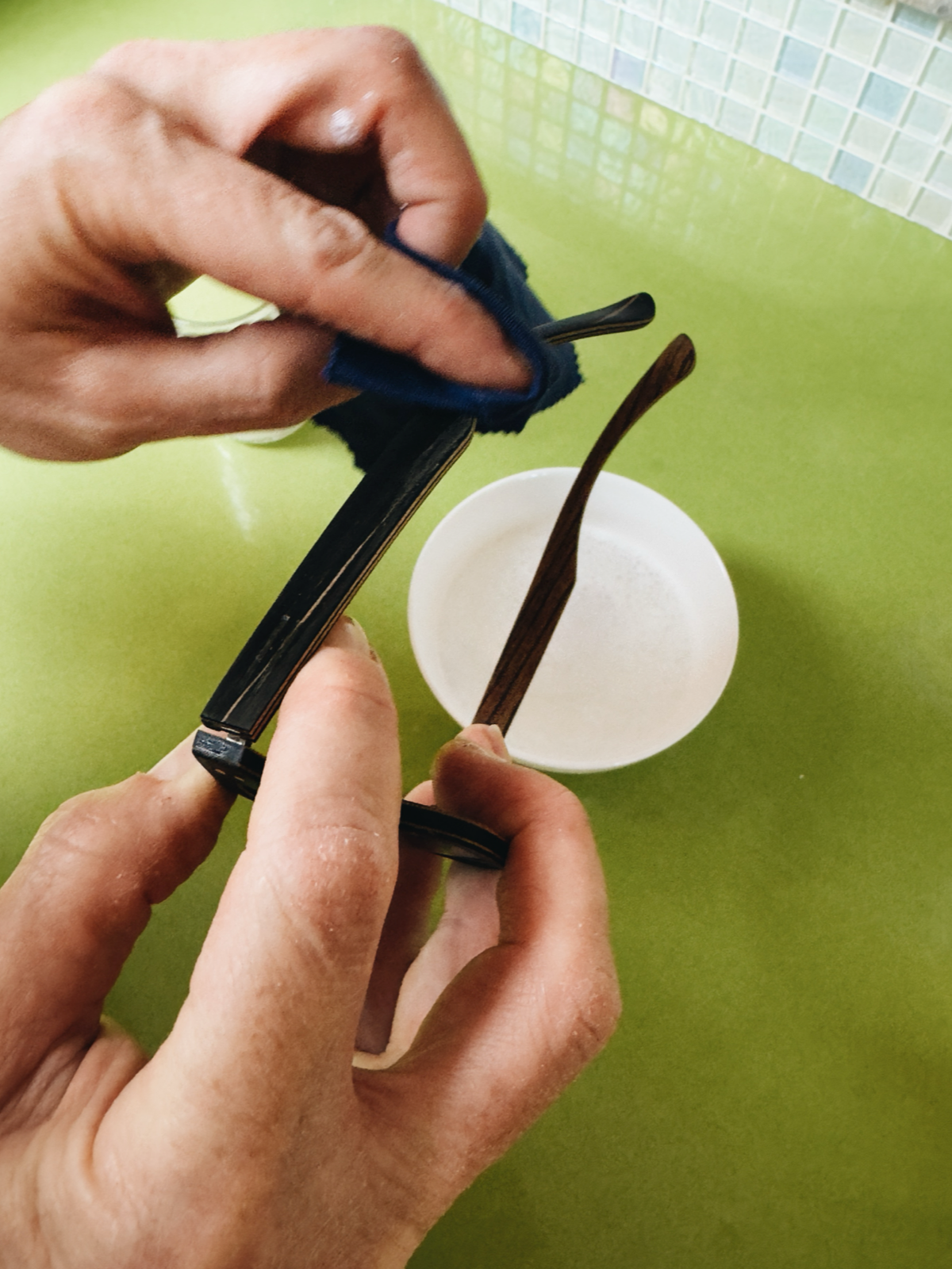 Step 4: Carefully cleaning the wooden sunglasses frames with a damp cloth.