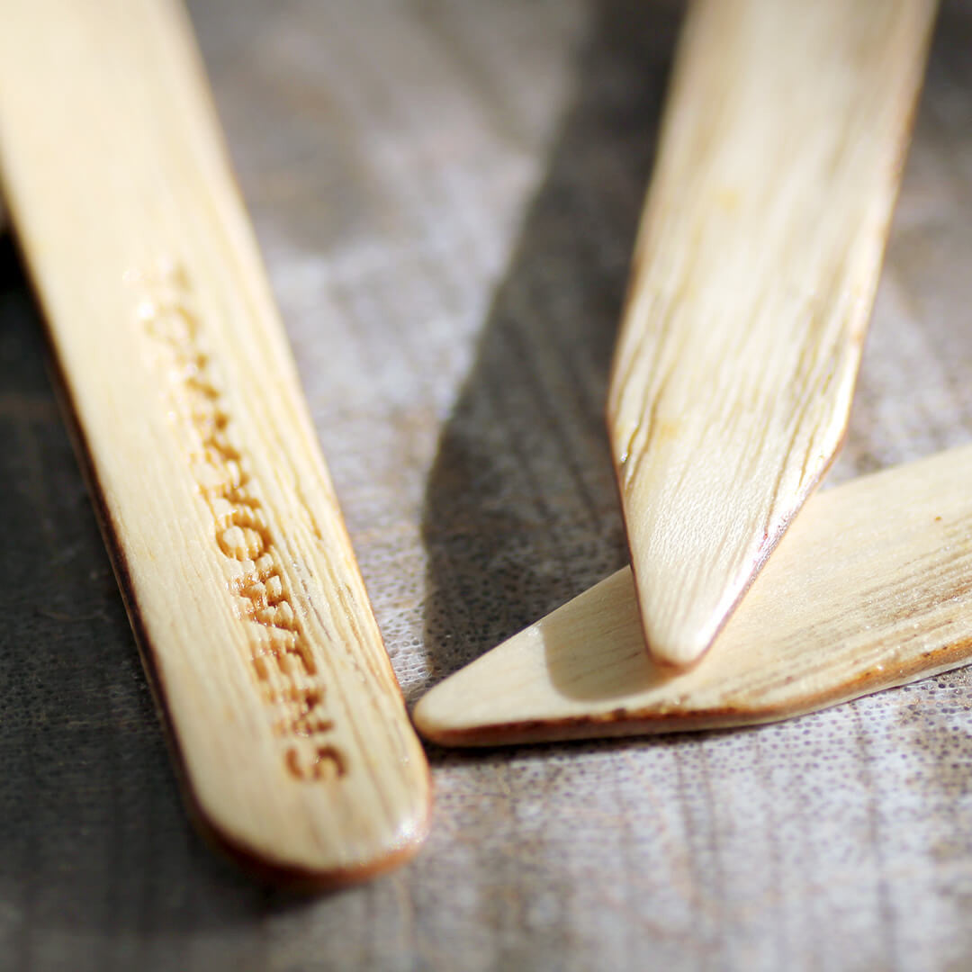 Ash wood collar stays casually scattered on a tabletop, highlighting their natural color and subtle grain.